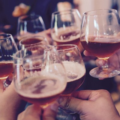 Stock image: people holding glasses of alcohol to 'cheers'